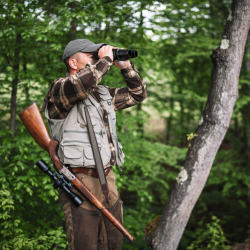 Hunter looking through his binoculars during a hunt.